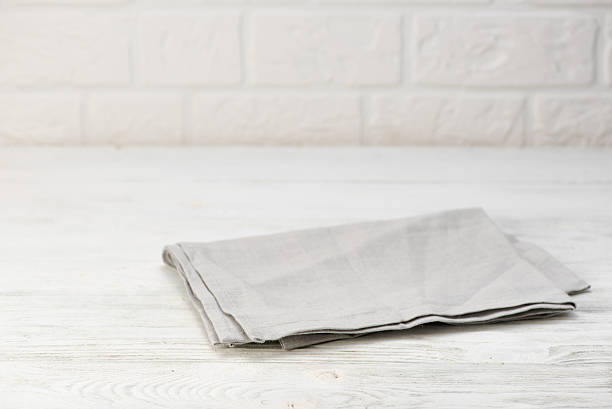 istock Gray napkin isolated on white wooden table. Copy space. Brick 627739656