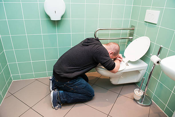 man vomiting in the toilet Man kneeling and vomiting in the toilet puke green color stock pictures, royalty-free photos & images
