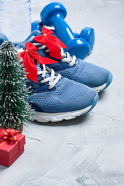 composición deportiva navideña con zapatos, mancuernas, regalo - holiday healthy lifestyle weight christmas fotografías e imágenes de stock
