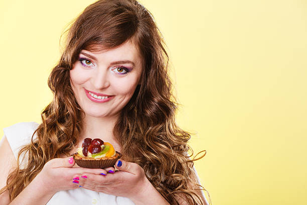 istock Smiling cute woman holds fruit cake in hand 627744476