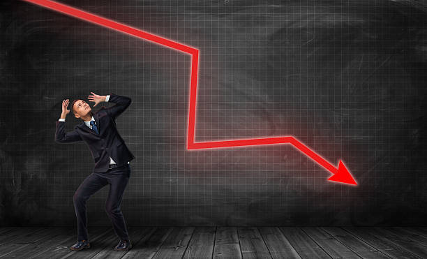 istock Small frightened businessman under huge red kinked arrow pointing down 627746730