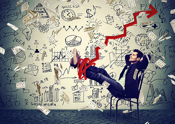 istock Successful business man relaxing in office under money rain 627747190