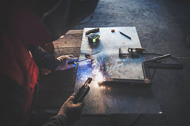 istock Man wealding steel bar overhead shot 627747192