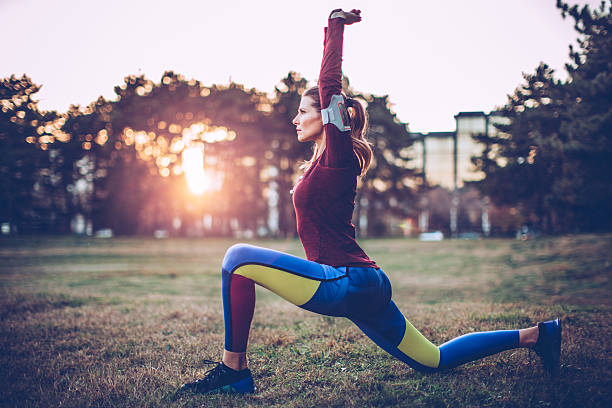 stretching prima di fare jogging  - women muscular build action activity foto e immagini stock