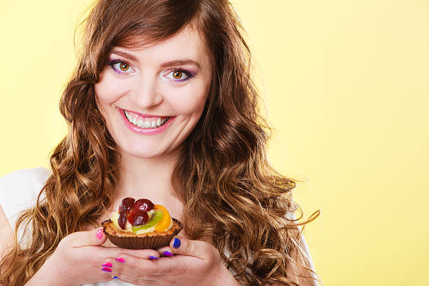 istock Smiling cute woman holds fruit cake in hand 627758806