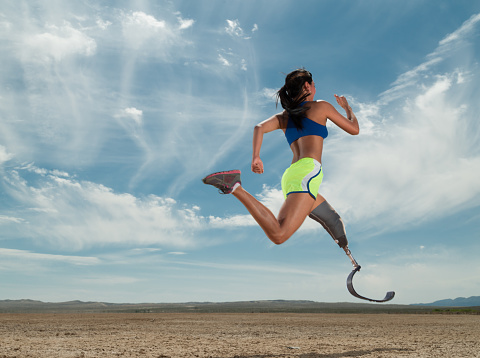 Mujeres asiáticas con pierna protésica corriendo en el desierto photo