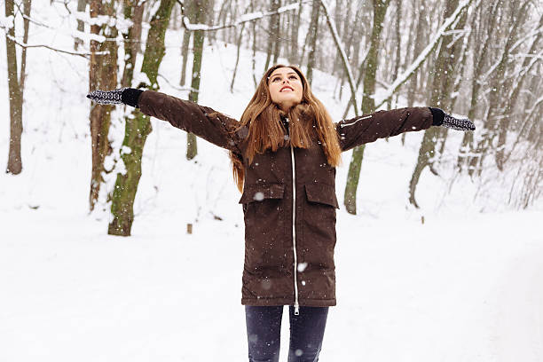 istock Woman warmly clothed in a cold winter snow forest with 627759834