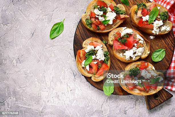 Italian Bruschetta With Tomatoes Feta And Basil Pesto Stock Photo - Download Image Now