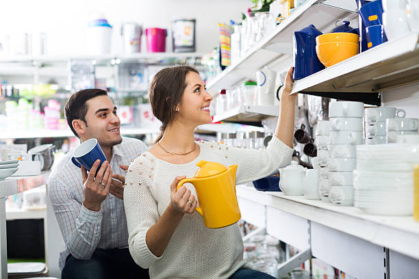 Couple buying ceramic Happy adult couple buying ceramic ware in the shop household equipment stock pictures, royalty-free photos & images