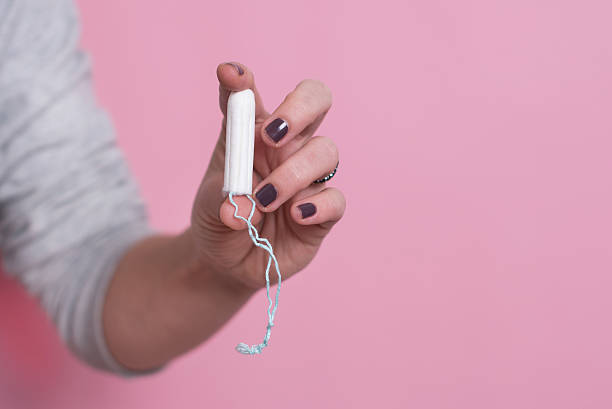 istock Woman's hand holding a clean cotton tampon 627778730