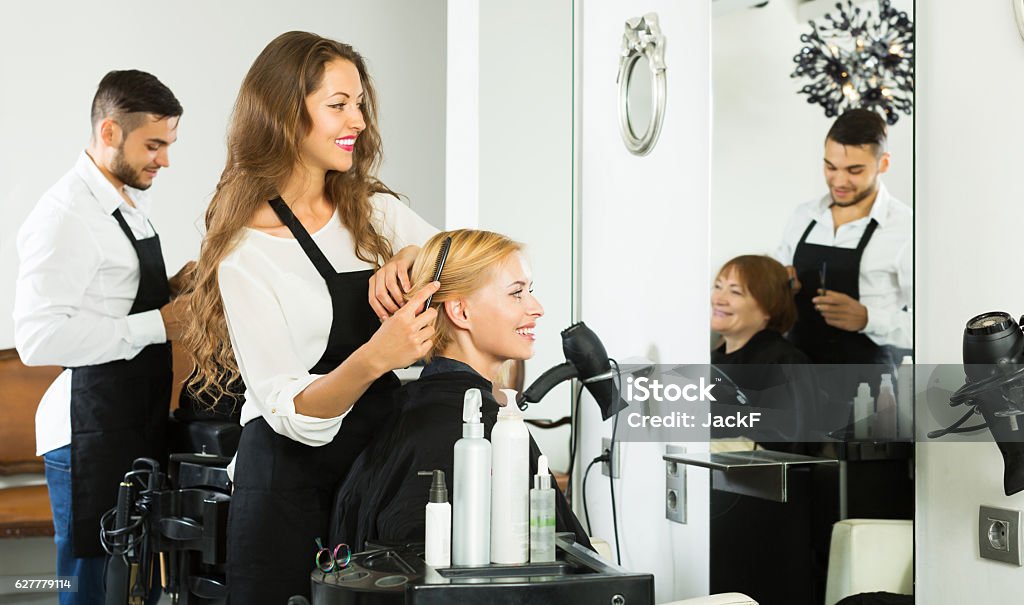 Woman hairdresser doing hairstyle Happy woman hairdresser doing hairstyle for young men 20-29 Years Stock Photo