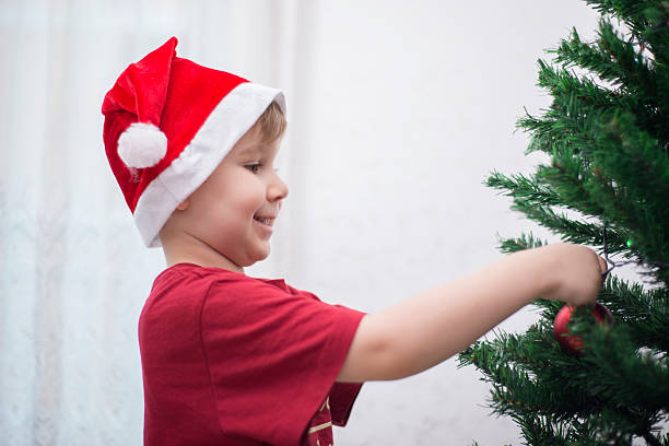 istock Happy Boy Decorating The Christmas Tree 627779232