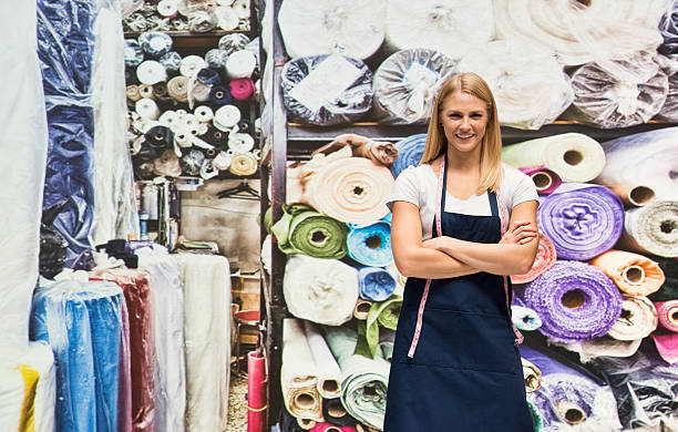 istock Smiling seamstress in textile industry 627779570
