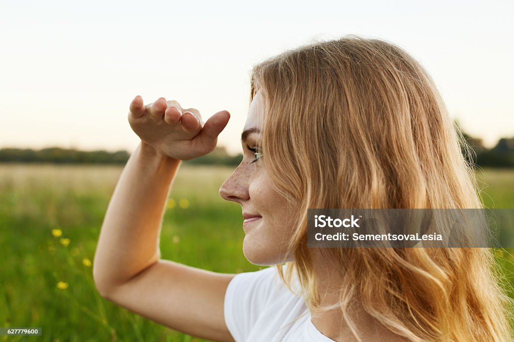 Girl with a pleasant smile and light straight hair look Adorable girl with a pleasant smile and light straight hair looking into the distance and trying to see something admirable Looking Stock Photo