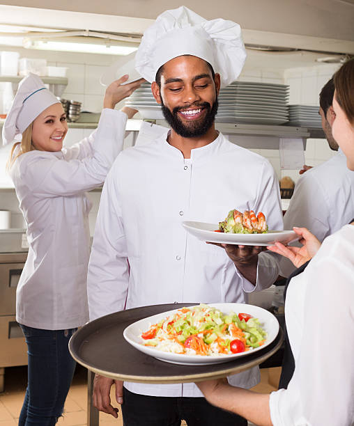 istock Waitress and cooking team in restaurant 627779604