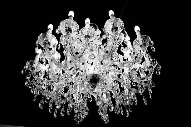 Crystal or glass chandelier on the ceiling with lights and candles