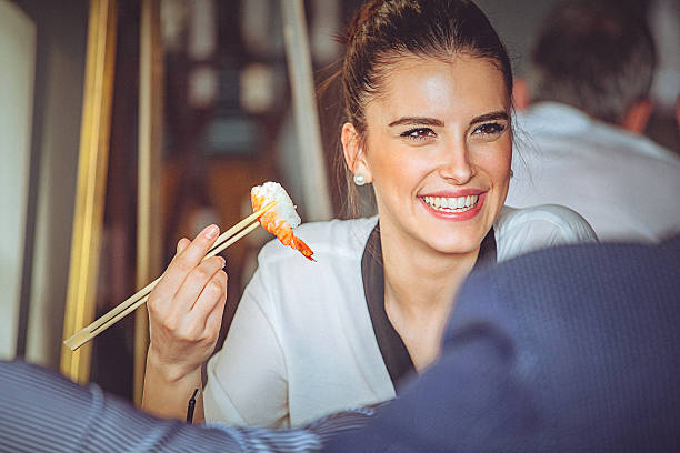 アジア料理店でランチタイムを楽しむ若い女性。 - sushi japan restaurant food ストックフォトと画像
