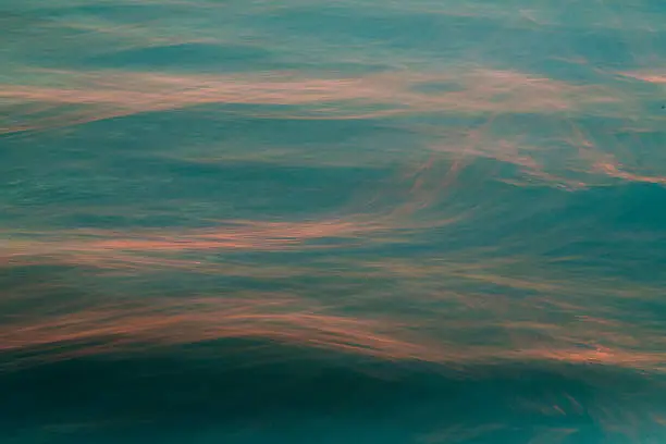 An abstract water photograph taken with a long exposure and in camera movement at sunset