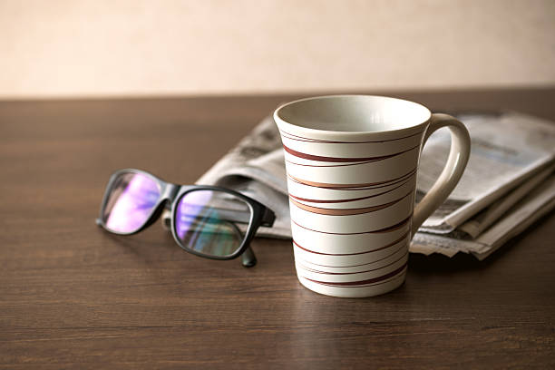 istock Newspaper reading glasses coffee cup and mobile phone on busines 627805552