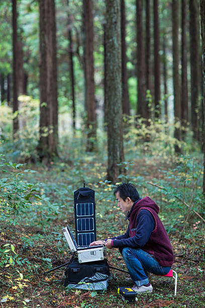 istock Researcher gathering data in forest with solar powered field station. 627811946