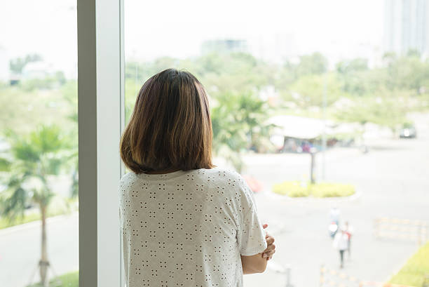 istock Woman looking out from her office window and thinking 627814864