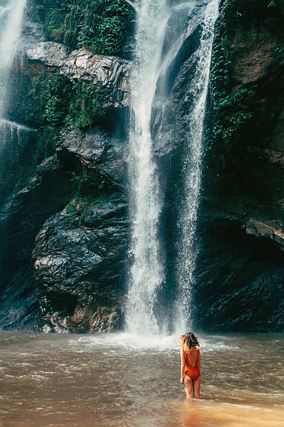 istock Woman swimming in tropical waterfall 627814950