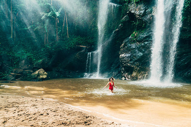 istock Woman swimming in tropical waterfall 627815008