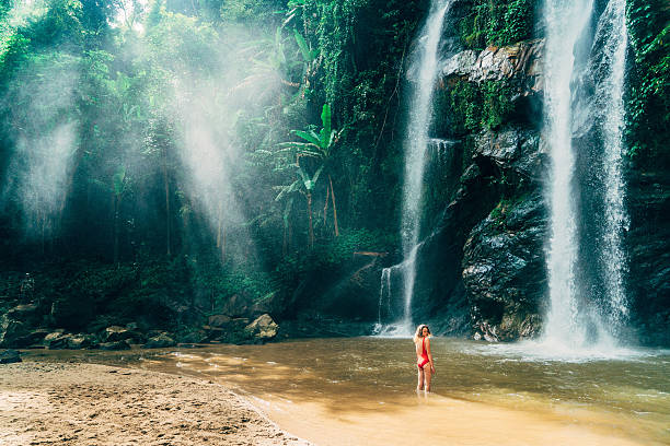 istock Woman swimming in tropical waterfall 627815066