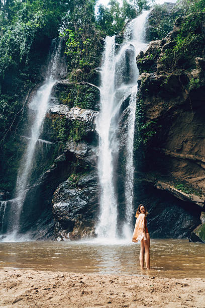 istock Woman swimming in tropical waterfall 627815184