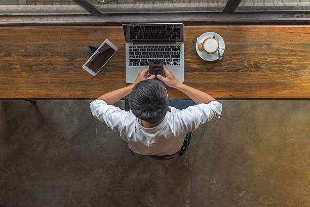 istock Businessman using smartphone and laptop beside tablet on wooden table 627815964