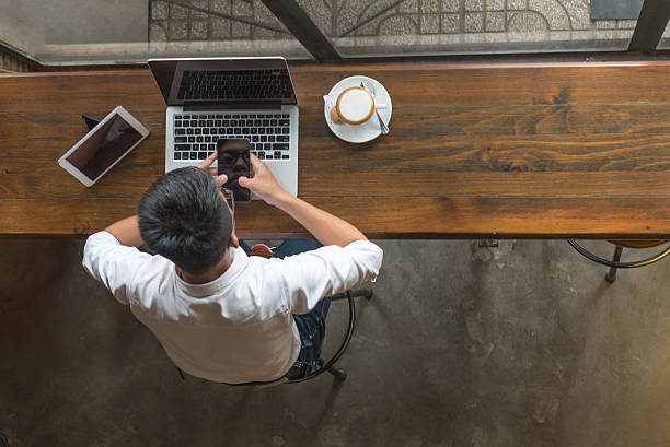 istock Businessman texting message on smartphone beside laptop and tablet 627816268