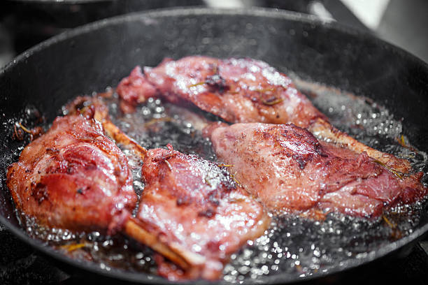 Goose drumstick frying in a pan