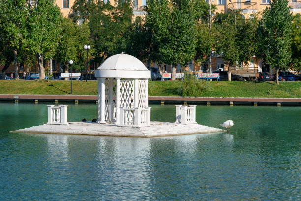 Astrakhan, Russia - September 5, 2016: Swan Lake. It is tourist attraction and favorite recreation area for everyone. White arch installed in the middle of the lake