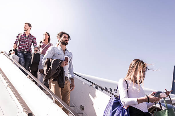 grupa młodych pasażerów wysiadających z samolotu. - people traveling travel leaving disembarking zdjęcia i obrazy z banku zdjęć