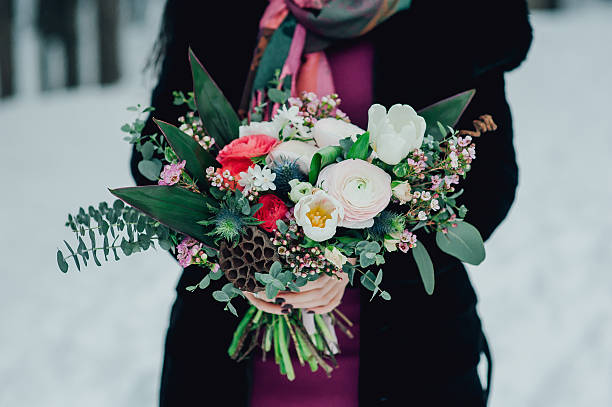 istock bride with a bouquet on the winter background 627842314