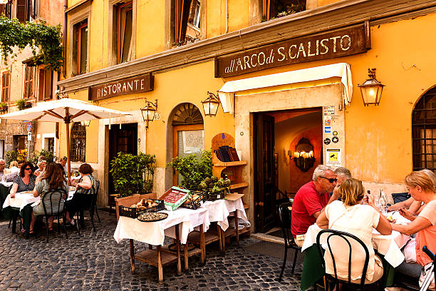 Rome, Italy - August 15 2023: Restaurant with outdoor seating at evening. Waiters serving food outside