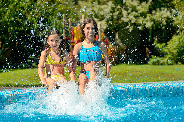 istock Kids in swimming pool have fun and splash in water 627855084