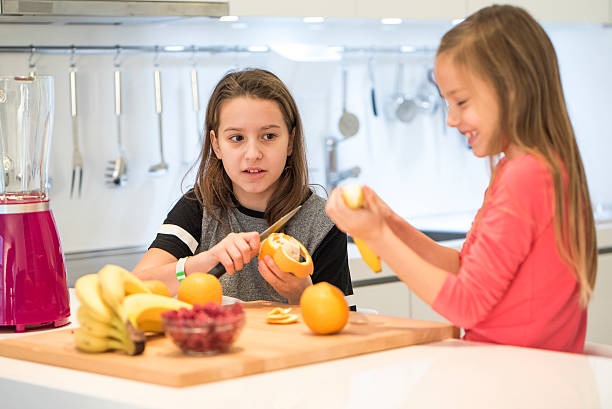 девушки делают здоровый фруктовый смузи - fruit salad fruit healthy eating making стоковые фото и изображения