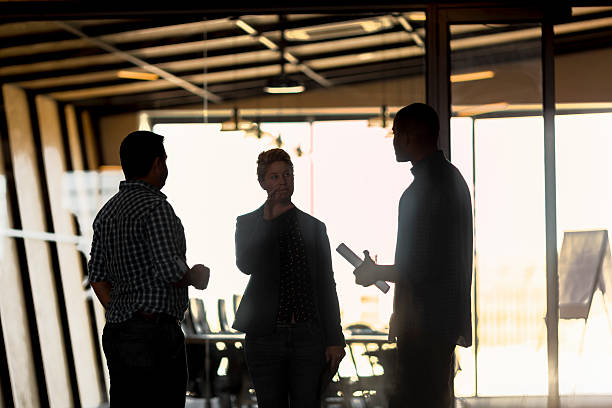istock Confident businesswoman talking with colleagues 627855798