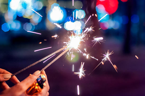 istock Woman holds glowing holiday sparkling hand fireworks 627857120