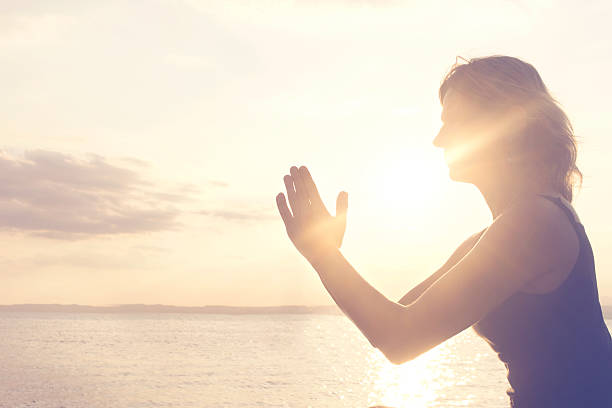 istock praying hands illuminated by the morning sun 627864064