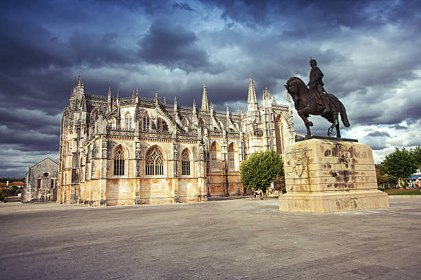 Monastery of Batalha Monastery of Batalha (Monastery of Saint Mary of the Victory) and statue of Nuno Alvares Pereira. batalha photos stock pictures, royalty-free photos & images