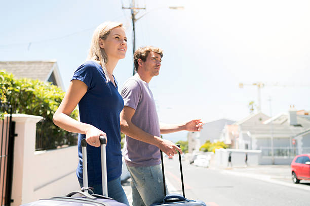 istock Couple standing with suitcases on sunny day 627864404