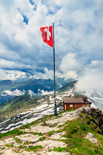 Swiss flag flying on the summit of the Faulhorn in the Bernese Oberland area of Switzerland.