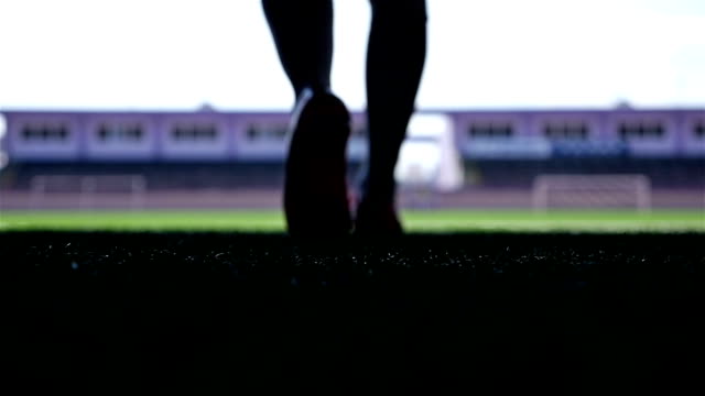 Silhouette of a football player going out to the stadium, slow motion
