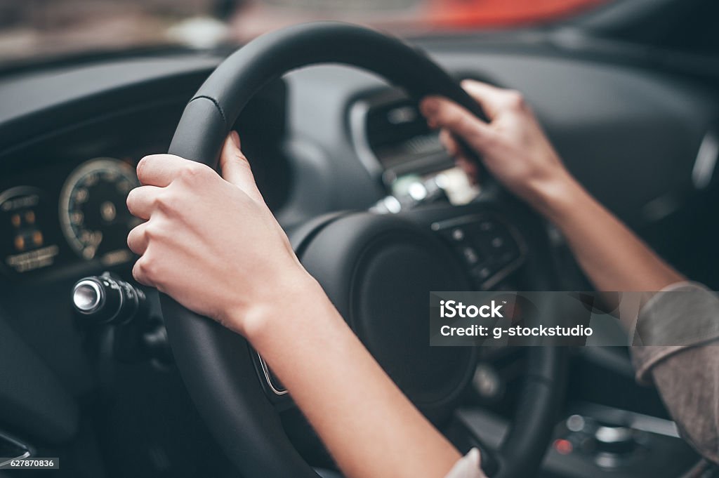 Always on the move. Close-up of female hands on steering wheel while driving a car Steering Wheel Stock Photo