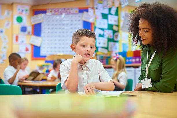 schüler vor seinem lehrer. - elementary student school uniform uniform education stock-fotos und bilder