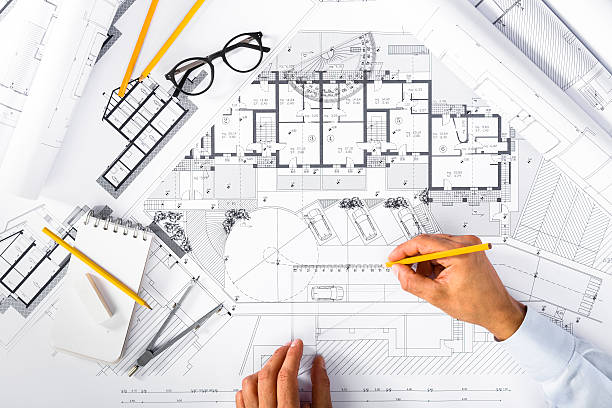 istock Construction plans and Male Hands drawing on blueprints 627871748
