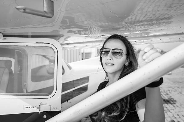 istock Young smiling woman standing near private plane 627872032