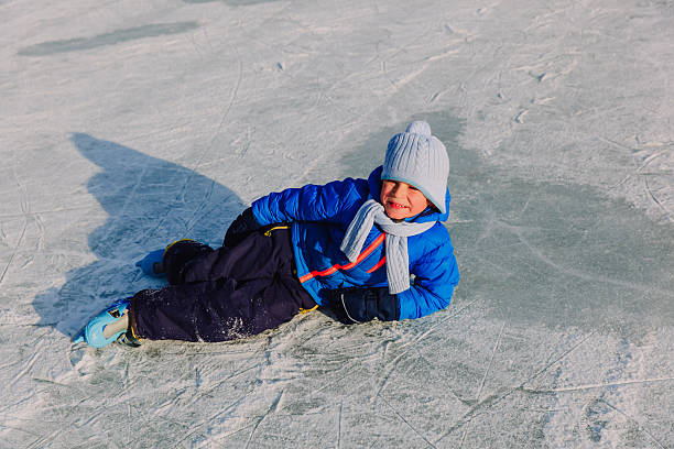istock cute little boy learning to skate in winter 627872656
